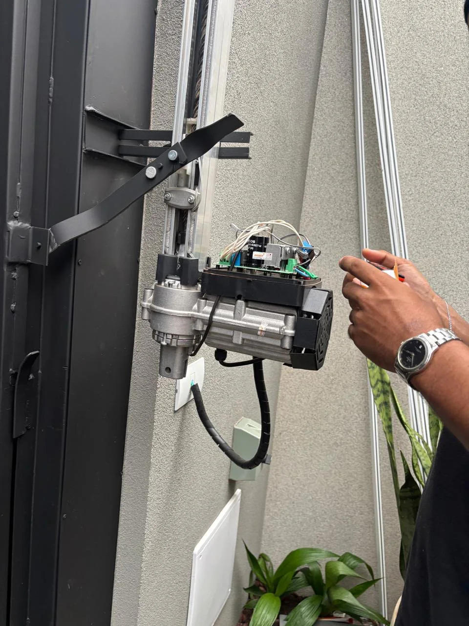 Técnico realizando a instalação de um motor de portão
